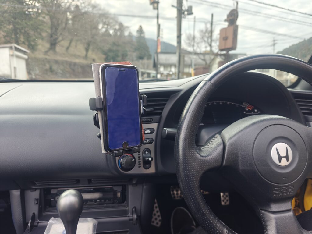 S2000のコクピットでステアリング横に設置されたスマホホルダーの使用例